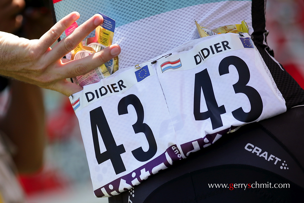 Laurent DIDIER of Luxembourg puts some food in his pocket at Annecy