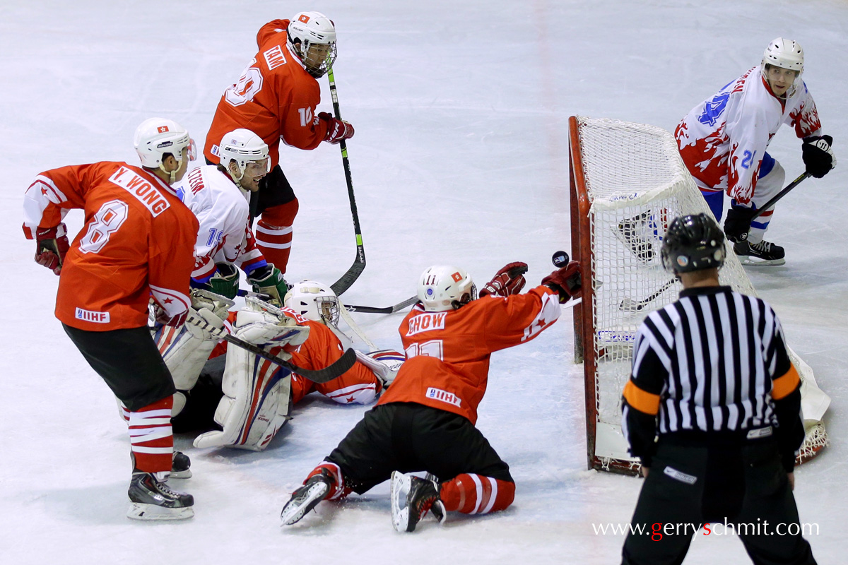 CHOW of Hongkong saves the puck for his beaten Goalie after the shot of HOLTZEM during WM Game (third division)