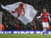 Lukas PODOLSKI lifts his thumb up in front of a Gunners flag after he scored against Bayern Munich