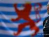 Burkard DISCH (national Coach of Volleyball Luxembourg) stands in front of the Flag 'Roude Leiw' 